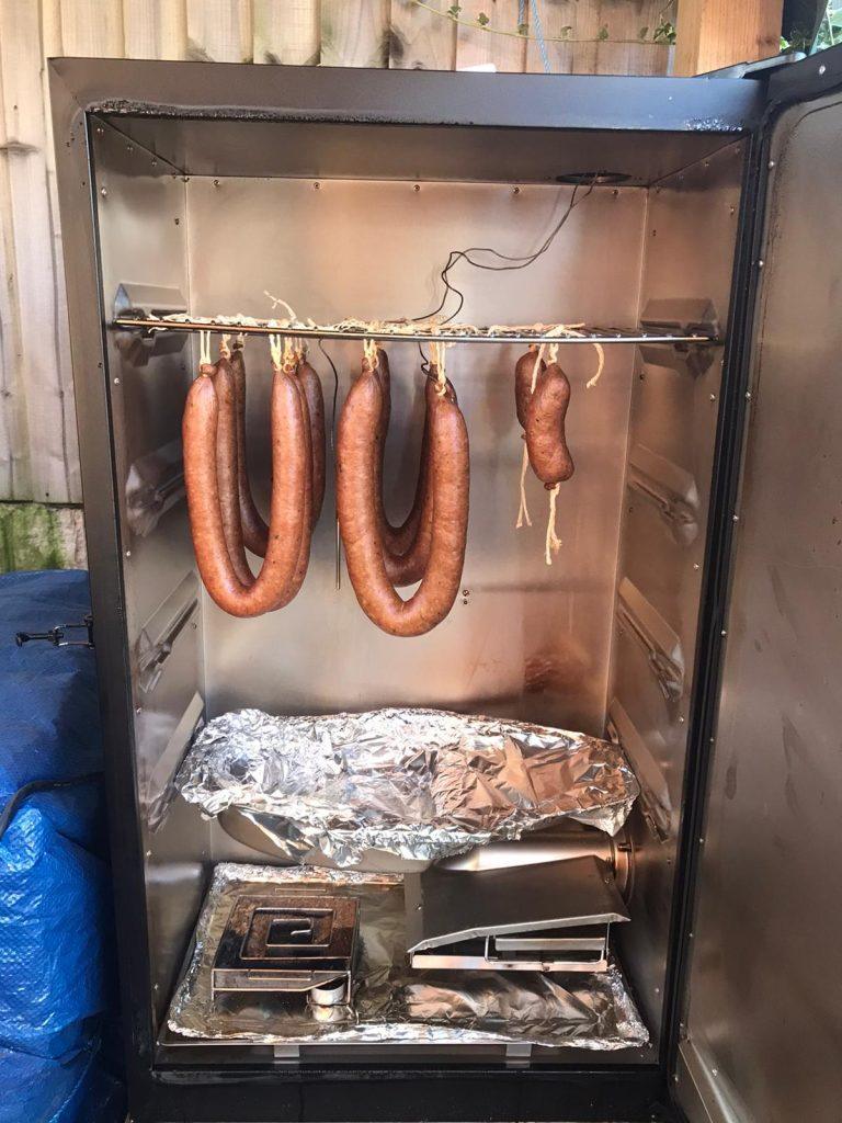 Polish sausage being smoked in a Masterbuilt brand smoker.